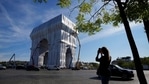 Onlooker takes a picture as workers put the final touch to wrap the Arc de Triomphe monument, in Paris. The "L'Arc de Triomphe, Wrapped" project by late artist Christo and Jeanne-Claude will be on view from, Sept. 18 to Oct. 3. The famed Paris monument will be wrapped in 25,000 square meters of fabric in silvery blue and with 3,000 meters of red rope.(AP Photo/Francois Mori) Onlooker takes a picture as workers put the final touch to wrap the Arc de Triomphe monument, in Paris. The "L'Arc de Triomphe, Wrapped" project by late artist Christo and Jeanne-Claude will be on view from, Sept. 18 to Oct. 3. The famed Paris monument will be wrapped in 25,000 square meters of fabric in silvery blue and with 3,000 meters of red rope.(AP Photo/Francois Mori)