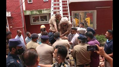 Police personnel rescuing the labourer at the Sector-4 house in Chandigarh on Friday. (HT Photo)