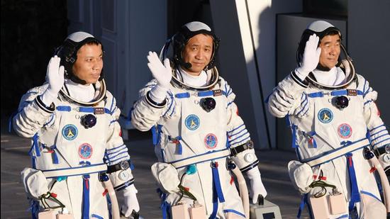 In this file photo, Chinese astronauts Nie Haisheng (C), Liu Boming (R) and Tang Hongbo wave during a departure ceremony before boarding the Shenzhou-12 spacecraft on a Long March-2F carrier rocket at the Jiuquan Satellite Launch Centre in the Gobi desert in northwest China. The three astronauts have completed the country’s longest crewed mission and returned to Earth. (AFP)