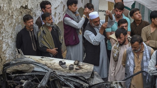 Afghan residents and family members of the victims gather next to a damaged vehicle inside a house, day after a US drone airstrike in Kabul on August 30(AFP) Afghan residents and family members of the victims gather next to a damaged vehicle inside a house, day after a US drone airstrike in Kabul on August 30(AFP)