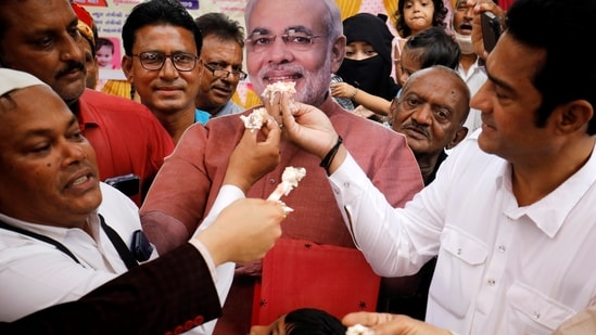 Here's how Prime Minister Narendra Modi's well-wishers from all over India celebrated his 71st birthday, In this picture, people can be seen offering cake to a cut-out of PM Modi in Ahmedabad.(REUTERS)