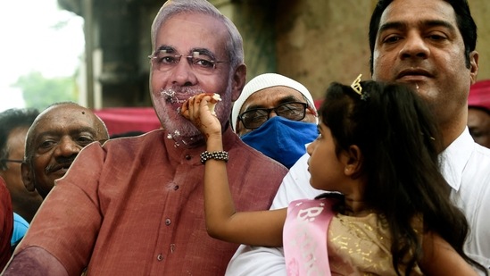 A girl offers cake to a life-size cutout of Indian Prime Minister Narendra Modi on the occasion of Modi's 71st birthday in Ahmedabad.(AFP)
