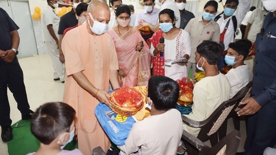 Uttar Pradesh Chief Minister Yogi Adityanath with Uttar Pradesh Minister of State (Independent Charge) Women's Welfare, Child Development and Nutrition Swati Singh distribute goods to beneficiaries during a program to celebrate 71st birthday of Prime Minister Narendra Modi at shelter home, in Lucknow.(PTI)