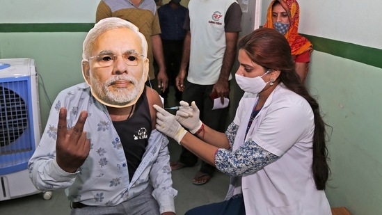 A beneficiary wears a face mask of PM Modi as he gets inoculated at a camp in Beawar on Friday. (PTI) A beneficiary wears a face mask of PM Modi as he gets inoculated at a camp in Beawar on Friday. (PTI)
