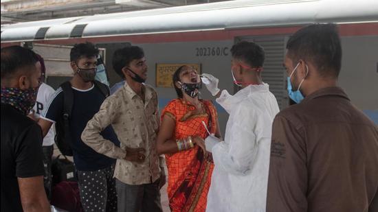 A healthcare worker collects swab sample for Covid-19 test of passengers arriving on outstation trains at Dadar station, in Mumbai on Wednesday, September 15. (Pratik Chorge/HT PHOTO)