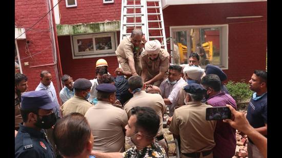 Police personnel rescuing the labourer at the Sector-4 house in Chandigarh on Friday. (HT Photo)