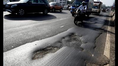 Motorists negotiate through potholes on Nerul flyover as resurfacing of flyovers on Sion-Panvel Highway not done before monsoon. (BACHCHAN KUMAR/HT)