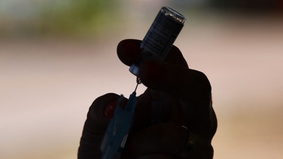 A healthcare worker prepares a dose of the AstraZeneca/Oxford Covid-19 vaccine at a drive-thru vaccination post in Brasilia on September 13, 2021. (Photo by EVARISTO SA / AFP)