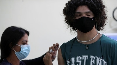A 14-year-old receives a shot of Covis-19 vaccine in Rio de Janeiro, Brazil, on Friday. (Reuters Photo)