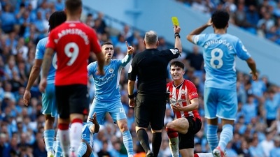 Southampton's Tino Livramento is shown a yellow card by referee Jonathan Moss. (Action Images via Reuters)