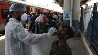 A health workers conducts a Covid-19 test on a passenger at a railway station in Mumbai. (Bhushan_Koyande/HT Photo) A health workers conducts a Covid-19 test on a passenger at a railway station in Mumbai. (Bhushan_Koyande/HT Photo)