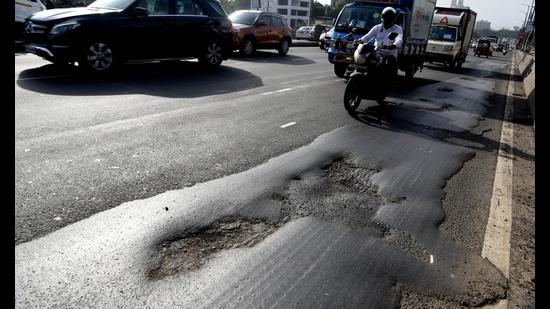 Motorists negotiate through potholes on Nerul flyover as resurfacing of flyovers on Sion-Panvel Highway not done before monsoon. (BACHCHAN KUMAR/HT) Motorists negotiate through potholes on Nerul flyover as resurfacing of flyovers on Sion-Panvel Highway not done before monsoon. (BACHCHAN KUMAR/HT)