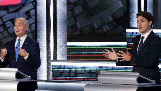 Conservative leader Erin O’Toole (L) and Canadian Prime Minister and Liberal leader Justin Trudeau discuss a point during the Canada elections French-language leaders debate at the Canadian Museum of History in Gatineau, Quebec on September 8. (AFP)