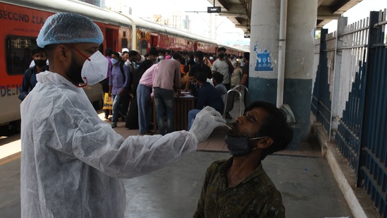 A health workers conducts a Covid-19 test on a passenger at a railway station in Mumbai. (Bhushan_Koyande/HT Photo) A health workers conducts a Covid-19 test on a passenger at a railway station in Mumbai. (Bhushan_Koyande/HT Photo)