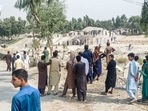 Taliban members and people gather at the site of a bomb explosion on Sunday. Taliban members and people gather at the site of a bomb explosion on Sunday. 