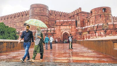 Tourists protect themselves from rain at Red Fort in Agra on September 17. (PTI) Tourists protect themselves from rain at Red Fort in Agra on September 17. (PTI)