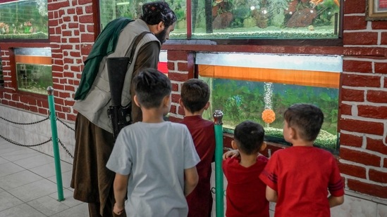 A Taliban fighter along with children look at aquariums at the Kabul Zoo.(AFP) A Taliban fighter along with children look at aquariums at the Kabul Zoo.(AFP)