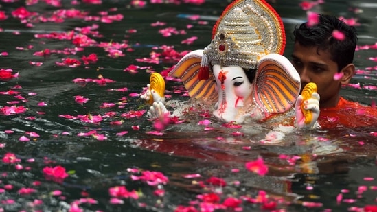 Here are a few pictures of how devotees all over India are bidding adieu to Lord Ganesh. In this still, an idol of Lord Ganesha is being immersed in the artificial pond at Dadar Chowpatty, Mumbai(HT Photo/Satish Bate)