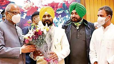 Punjab governor Banwarilal Purohit congratulates chief minister Charanjit Singh Channi after taking oath as the new chief minister at Raj Bhawan in Chandigarh on Monday. Congress leader Rahul Gandhi, PPCC chief Navjot Singh Sidhu and other party leaders were present on the occasion. (ANI) Punjab governor Banwarilal Purohit congratulates chief minister Charanjit Singh Channi after taking oath as the new chief minister at Raj Bhawan in Chandigarh on Monday. Congress leader Rahul Gandhi, PPCC chief Navjot Singh Sidhu and other party leaders were present on the occasion. (ANI)
