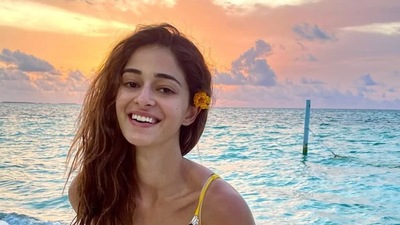 Ananya Panday posing with a yellow flower behind her ear. Ananya Panday posing with a yellow flower behind her ear.