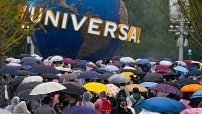 People wearing raincoats and carrying umbrellas walk through a plaza near the entrance of Universal Studios Beijing in Beijing, Monday, Sept. 20, 2021. Thousands of people brave the rain visit to the newest location of the global brand of theme parks which officially opens on Monday. (AP Photo/Andy Wong) People wearing raincoats and carrying umbrellas walk through a plaza near the entrance of Universal Studios Beijing in Beijing, Monday, Sept. 20, 2021. Thousands of people brave the rain visit to the newest location of the global brand of theme parks which officially opens on Monday. (AP Photo/Andy Wong)
