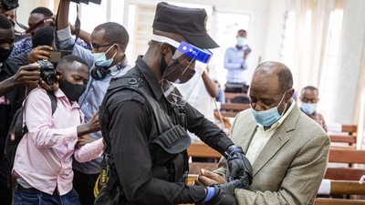 In this photo taken on September 14, 2020 "Hotel Rwanda" hero Paul Rusesabagina is handcuffed by a police officer after his pre-trial court session at the Kicukiro Primary court in Kigali, Rwanda. (AFP) In this photo taken on September 14, 2020 "Hotel Rwanda" hero Paul Rusesabagina is handcuffed by a police officer after his pre-trial court session at the Kicukiro Primary court in Kigali, Rwanda. (AFP)