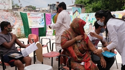 A health care worker administers a dose of the Covid-19 vaccine at a vaccination camp in New Delhi. (Bloomberg) A health care worker administers a dose of the Covid-19 vaccine at a vaccination camp in New Delhi. (Bloomberg)