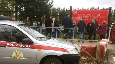 People stand behind the fence near the Perm State University with the a Posguardia (National Guardia) on the left, in Perm, Russia, (AP) People stand behind the fence near the Perm State University with the a Posguardia (National Guardia) on the left, in Perm, Russia, (AP)