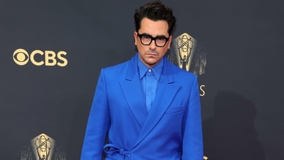 Dan Levy attends the 73rd Primetime Emmy Awards in an all-blue stunning suit. He chose a layered wrap blazer, dress shirt, and pants teamed with his signature black glasses and matching platform shoes. (AFP) Dan Levy attends the 73rd Primetime Emmy Awards in an all-blue stunning suit. He chose a layered wrap blazer, dress shirt, and pants teamed with his signature black glasses and matching platform shoes. (AFP)