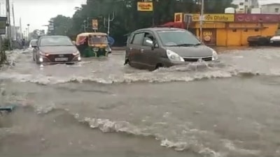 Vehicles navigating a waterlogged road in Kolkata on Monday. (HT Photo)