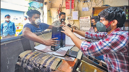 People purchase liquor from a shop at Kalyanpuri, during lockdown, last year. At least 23 wards in Delhi will have no liquor shop open since liquor licences will stay suspended between October 1 and November 16, for smooth transition under the new excise policy regime. (Amal KS/HT PHOTO)