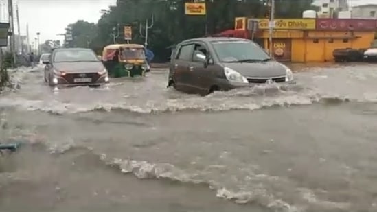 Vehicles navigating a waterlogged road in Kolkata on Monday.(HT Photo)