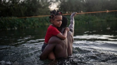 A Haitian migrant carries a child while wading across the Rio Grande from Del Rio, Texas, to return to Ciudad Acuña, Mexico, on Sept. 19. Of the roughly 1.8 million Haitians living outside their homeland, the United States is home to the largest Haitian immigrant population in the world, numbering 705,000 people from the Western Hemisphere's poorest country, AP reported. (Felix Marquez / AP) A Haitian migrant carries a child while wading across the Rio Grande from Del Rio, Texas, to return to Ciudad Acuña, Mexico, on Sept. 19. Of the roughly 1.8 million Haitians living outside their homeland, the United States is home to the largest Haitian immigrant population in the world, numbering 705,000 people from the Western Hemisphere's poorest country, AP reported. (Felix Marquez / AP)