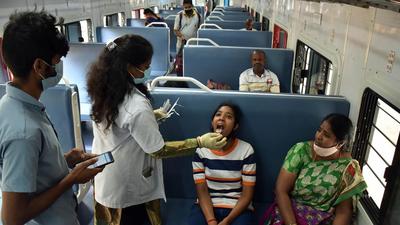 A healthcare worker collects a swab sample of a girl for the Covid test inside a train compartment, in Bengaluru, Karnataka. (ANI) A healthcare worker collects a swab sample of a girl for the Covid test inside a train compartment, in Bengaluru, Karnataka. (ANI)