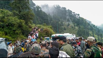 Police personnel and locals at the site where an Indian Army helicopter crashed in Udhampur district on Tuesday. (PTI)