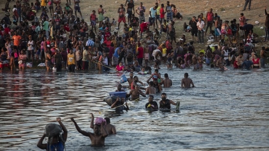 Migrants, many from Haiti, attempt to cross the Rio Grande from Del Rio, Texas, to return to Ciudad Acuña, Mexico, on September 19. Many Haitians began attempting to enter the US in the 1980s by sea. Most of them were cut off by the Coast Guard and perhaps given a cursory screening for asylum eligibility, David FitgGerald, a sociology professor at the University of California, San Diego told AP.(Felix Marquez / AP)