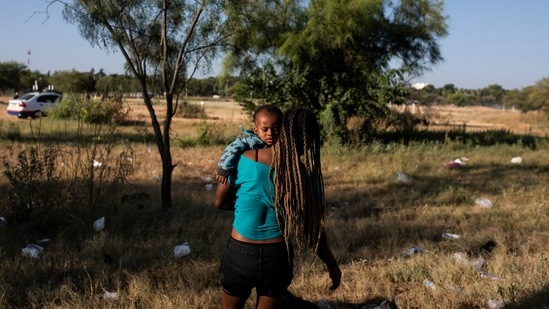 A woman carries a child away from the Rio Grande river after crossing it from Del Rio, Texas, to return to Ciudad Acuña, Mexico, on September 20. Unlike Central Americans, Haitians have generally not been deported from Mexico. So far this year, 19,000 have requested asylum in Mexico, a figure second only to Hondurans. In the previous two years, only about 6,000 Haitians had applied each year.(Felix Marquez / AP)