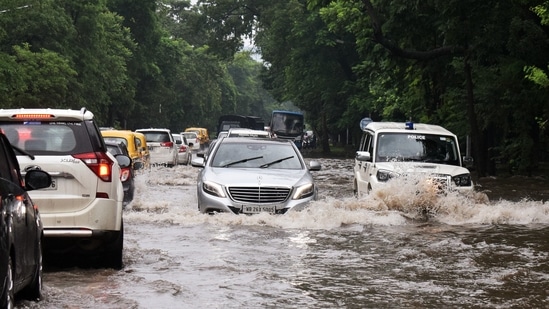 Vehicles wade through a waterlogged road after heavy rainfall in Kolkata.(ANI)
