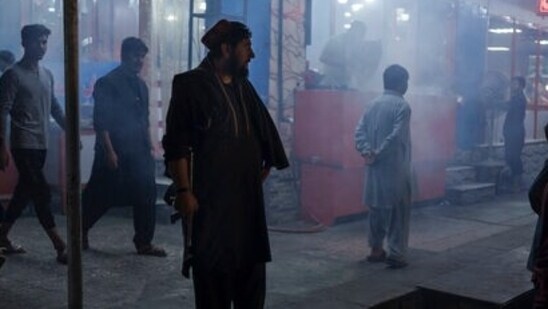 A Taliban fighter stands in the corner of a busy street at night in Kabul, Afghanistan.(AP file photo)