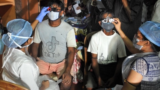 An eye doctor checks an artist's eye during free eye camp for the artistsans of Kumartuli ahead of Durga puja festival, organised by Priyamvada Birla Arvind Eye Hospital, in Kolkata.(PTI)
