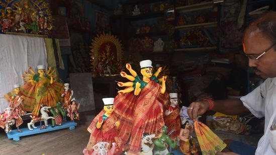 An artist decorates an idol of Goddess Durga ahead of Durga Puja festival at Kumartuly, Kolkata.(PTI)