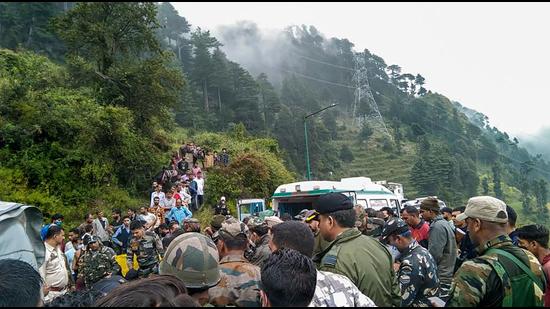 Police personnel and locals at the site where an Indian Army helicopter crashed in Udhampur district on Tuesday. (PTI)