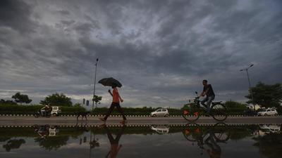 A pedestrian walks under an umbrella amid light rains at Rajghat Bus Depot, in New Delhi. (HT archive) A pedestrian walks under an umbrella amid light rains at Rajghat Bus Depot, in New Delhi. (HT archive)