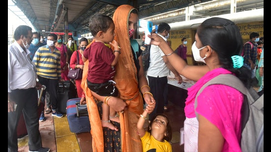 A BMC health worker checks temperatures before Covid-19 test of passengers arriving on outstation trains at Dadar station, in Mumbai on Tuesday, September 21. (Anshuman Poyrekar/HT photo)