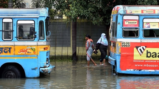 Commuters wade through a waterlogged road after heavy rains in Kolkata, on Tuesday, (PTI) Commuters wade through a waterlogged road after heavy rains in Kolkata, on Tuesday, (PTI)