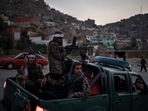 Taliban fighters sit on the back of a pickup truck as they stop on a hillside in Kabul, Afghanistan. Taliban fighters sit on the back of a pickup truck as they stop on a hillside in Kabul, Afghanistan.