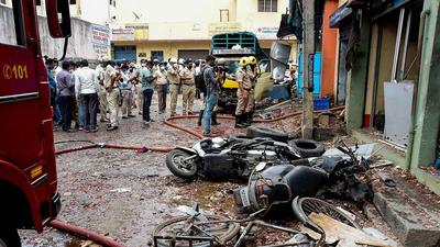 Charred remains of a vehicles after a blast at New Tharagupet area in Benagaluru on Thursday. At least 2 people died in suspected cracker blast. (PTI) Charred remains of a vehicles after a blast at New Tharagupet area in Benagaluru on Thursday. At least 2 people died in suspected cracker blast. (PTI)