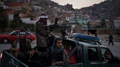 Taliban fighters sit on the back of a pickup truck as they stop on a hillside in Kabul, Afghanistan. (AP)