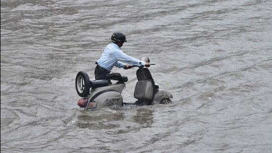A scooterist tries to make his way through waterlogged road near Millar Gang area in Ludhiana on Thursday. The city recorded 96.4mm rain till afternoon (Gurpreet Singh/HT)