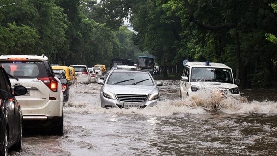 Vehicles wade through a waterlogged road after heavy rainfall in Kolkata.(ANI)